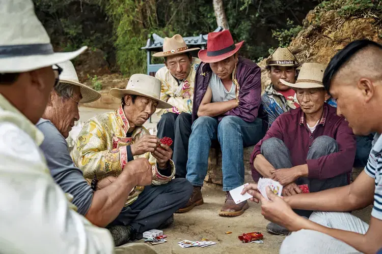 Mosuo men play an afternoon game of cards by Lugu Lake. Image by Jason Motlagh. China, 2017.<br />
