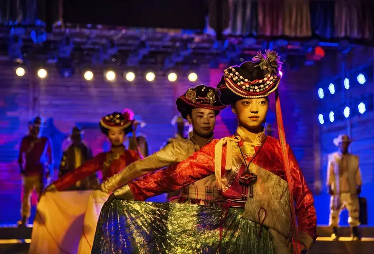 Mosuo women perform a nighttime cultural show for Chinese tourists. Image by Jason Motlagh. China, 2017.<br />
