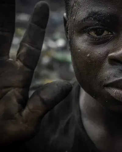 An Onitsha laborer with soot-covered hands from working at a burning site. Image by Larry C. Price. Nigeria, 2018.