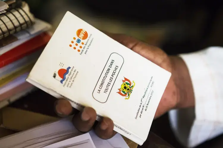 Moussa Tchangari, an activist and head of Alternatives, an NGO, holds a copy of the Nigerien Constitution at his office in Niamey, Niger, on Jan. 10, 2018. Image by Joe Penney. Niger, 2018.