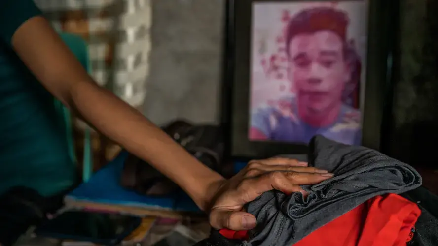 MEMORIES. Stanley Jungco’s sister holds on to memories of her brother. His body remains in a mortuary in Fuzhou, China. Image by Martin San Diego. Philippines, undated.