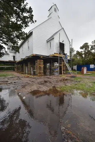 William Adams with Landmark Building and Design descends from the Ocracoke United Methodist Church on School Road where it has been elevated to accommodate storm surge after damage sustained during Hurricane Dorian in 2019. Image by Dylan Ray. United States, undated.