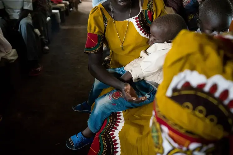 Diria sings in church as her son Abraham sleeps on her lap, June 30, 2019. Image by Adriane Ohanesian. Uganda, 2019.