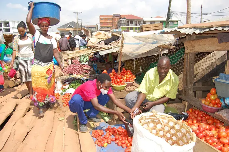 Traders at Ggaba market have constructed a raised floor on top of water using timber. They think this will work for a mean time with hope that ground will soon dry. Image by Sarah Mawerere and Noah Omuya. Uganda, 2020.