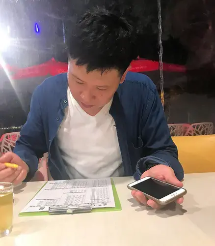 Wei Jiang orders dinner for an English-speaking journalist using his cell phone’s Google Translate app to communicate with her. Image by Melissa McCart. Taiwan, 2018.