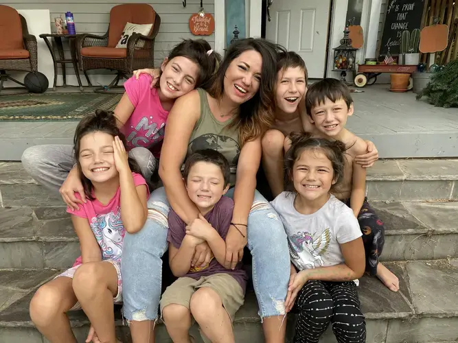 Ashley Fitzgibbon and her six children sit on the front steps of their Oklahoma City rental home. Fitzgibbon lost her income when the state shut down at the end of March. The property she rents was not protected by the CARES Act. She has received four eviction notices since May and has paid her rent by borrowing money and doing odd jobs. (Clockwise: Judah, 10, Griffin, 8, M’kenna Lou Ann, 6, Rorke, 5, Adaley Joy, 9, Jayden Grace, 12)