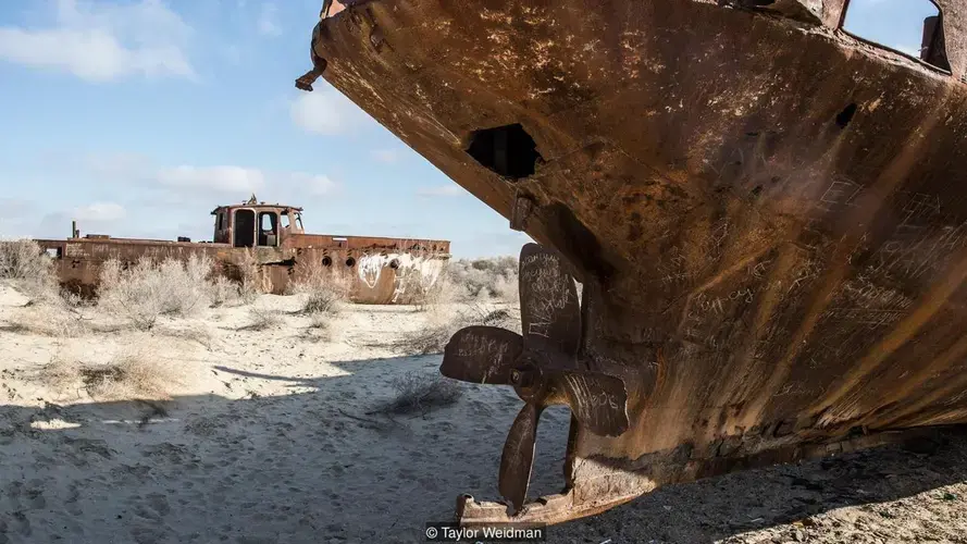 Rusting ships sit in the desert in the former port in Moynaq, Uzbekista. Image by Taylor Weidman. Uzbekistan, 2018.