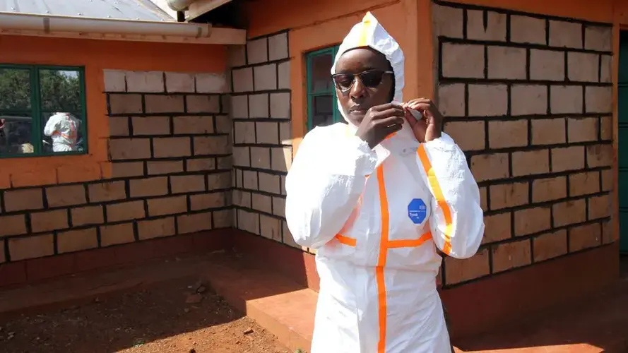 Millicent Minayo and her colleagues have to wear full protective clothing while taking samples in the villages. Image by Jacob Kushner. Kenya, undated.