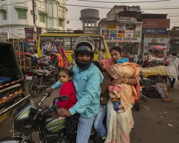 A family on a motorbike makes their way through Patna’s dense traffic during the evening commute. In theory, the state transport department oversees emissions testing, but the process is rife with bribery and lax enforcement. Image by Larry C. Price. India, 2018.