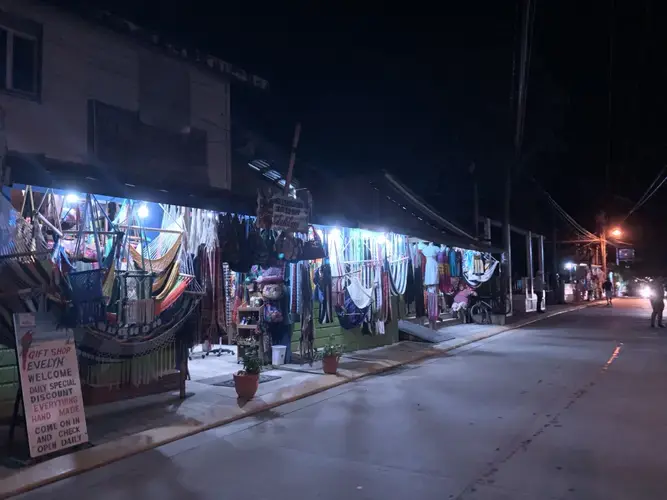 A row of souvenir shops illuminated at night in West End] Image by Jack Shangraw. Honduras, 2019.
