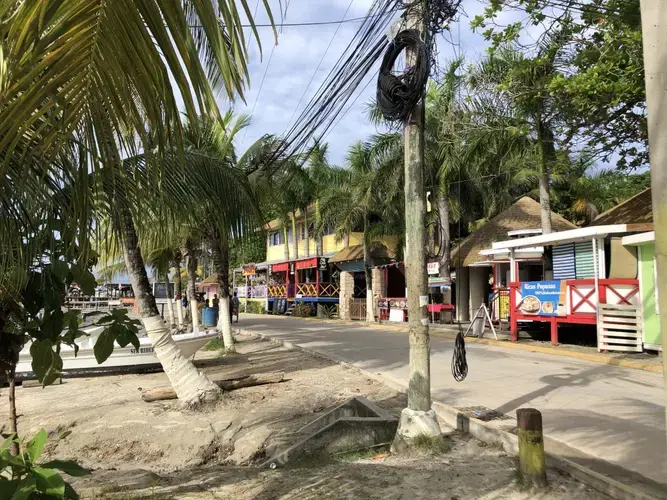 The main street of West End, mostly occupied by tourist-friendly bars, restaurants, souvenir shops, and diving businesses. Image by Jack Shangraw. Honduras, 2019.