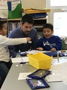 In the kindergarten class. Two students were showing Egan their works. Image by Thea Gu. United States, 2017.