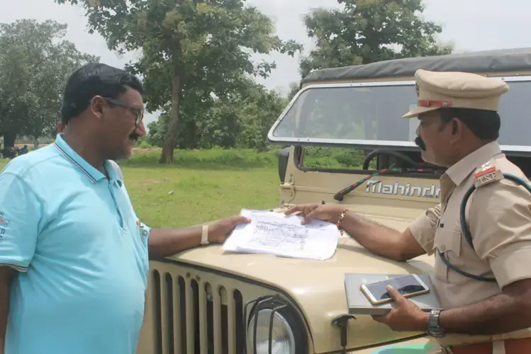 Sherif (left) and another forest reserve officer with the plans for the new village. Image by Vandana Menon. India, 2019.