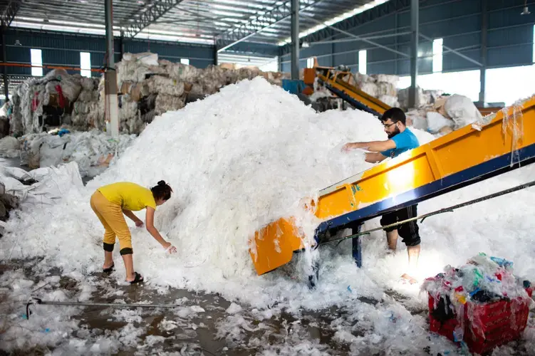 Shahid Ali (right) and a coworker at BioGreen Frontier, one of scores of recycling factories that popped up in Malaysia after China banned most plastic waste. Image by Sebastian Meyer. Malaysia, 2020.