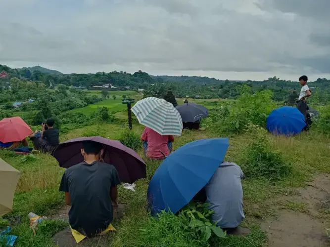 People sit at the top of a hill searching for a 3G internet signal in Mrauk-U, Rakhine State, Myanmar. Following a 14-month block on all internet services, the Myanmar government restored 2G services in August but continues to block 3G and 4G networks in eight conflict-affected townships, including Mrauk-U. Taken on August 26. Myanmar, 2020.<br />