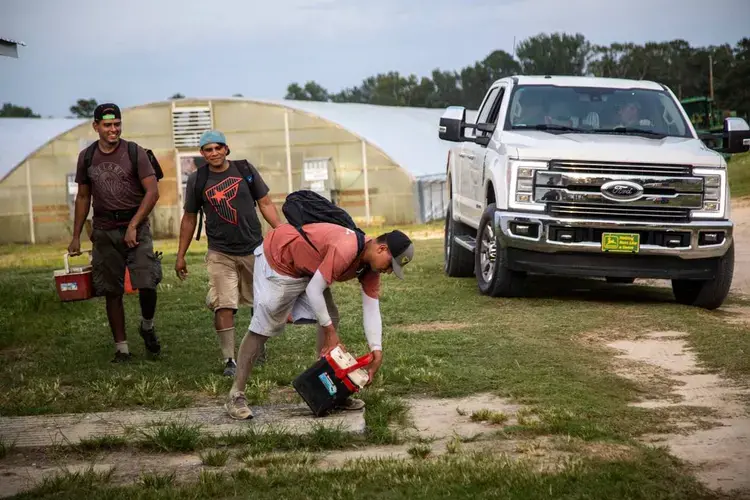 Farmworkers return from a day of working in the fields at a Johnston County farmworker camp Thursday August 27, 2020. Image by Travis Long. United States, 2020.