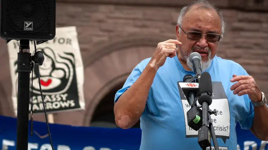 Raphael Fobister stands before a crowd and describes the constant ringing in his ears, a symptom of mercury poisoning. Image by Shelby Gilson. Canada, 2019.