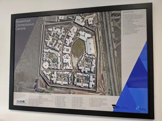 An aerial view of Ravenhall hangs in Col Caskie's office. Image by Rae Ellen Bichell / Mountain West News Bureau. Australia, 2020.