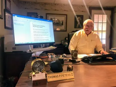 Tom Peters, the former chair of the Maine Criminal Justice Academy’s complaint review committee, shows the Sun Journal article that informed him of an investigation into former Oxford County Sheriff Wayne Gallant. “I raised it as an issue to discuss if we wanted to open it,” he said. The academy decided to wait to review Gallant’s law enforcement certification, and it lapsed after two years. Image by Callie Ferguson/BDN. United States.<br />
