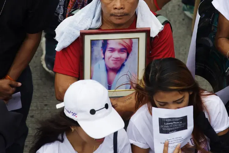 A father of a slain drug suspect clutches a photograph of his late son at a rally in Quezon City, on July 24, 2017. Image by Pat Nabong. Philippines, 2017.