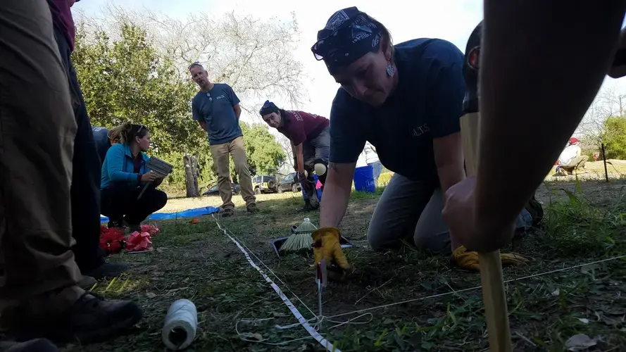 Volunteer anthropologists from Texas universities prepare a grave site on Jan. 3, 2017, where unidentified migrant remains were buried without DNA samples or other means of identification. Image by Kristian Hernandez. United States, 2017.