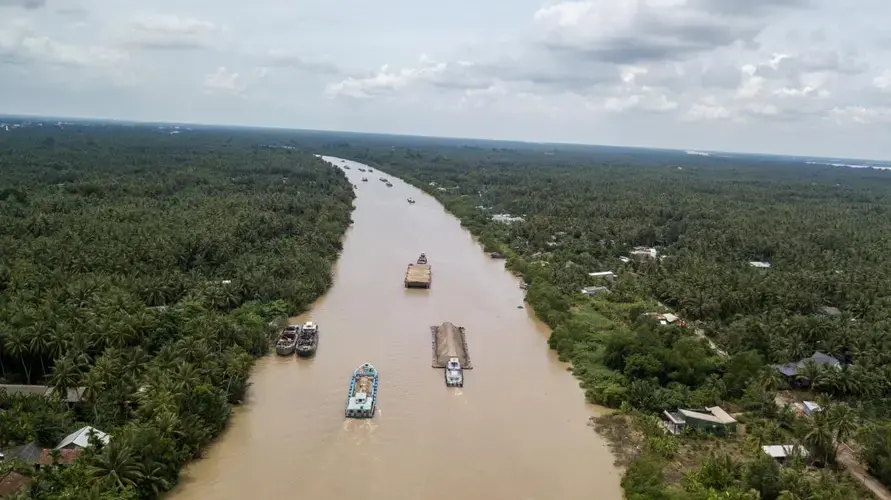 Sand barges motor down the Cho Gao canal en route to Ho Chi Minh City. Barges typically hold 700 tons of sand, though some hold up to 1,600 tons. Image by Sim Chi Yin. Vietnam, 2017.