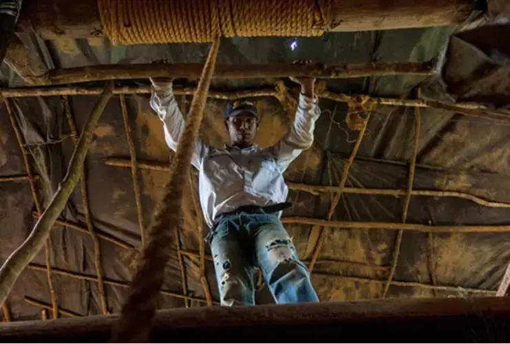 A small-scale miner awaits as the author is winched up after descending 40 meters (130 feet) into a Venezuelan mining shaft. Image by Bram Ebus. Venezuela, 2017.