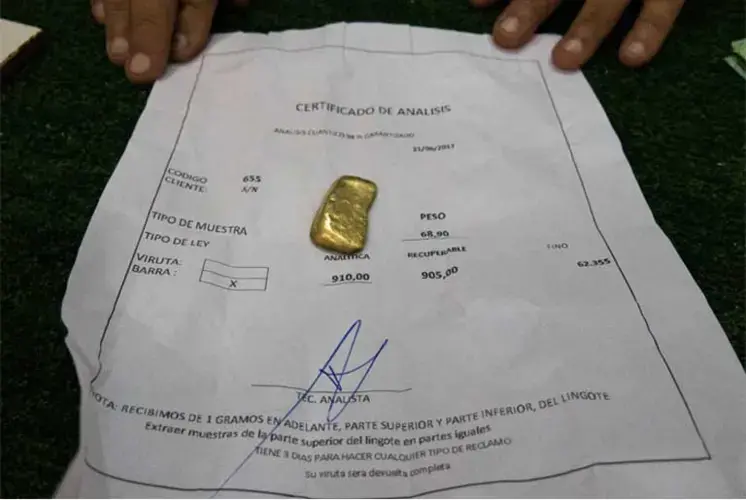 A gold trader in Tumeremo displays 68.9 grams of gold he just certified. The Orinoco Mining Arc is claimed to hold $100 billion in as yet uncertified and hidden minerals. Image by Bram Ebus. Venezuela, 2017.<br />
