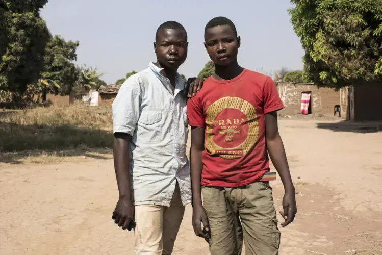 (L) Thomas Muyumba (16) used to work in a cobalt mine, but is now on an Apple funded apprenticeship. His friend, (R) Lukasa (15) continues to work in a cobalt mine. Image by Sebastian Meyer. Democratic Republic of Congo, 2018.