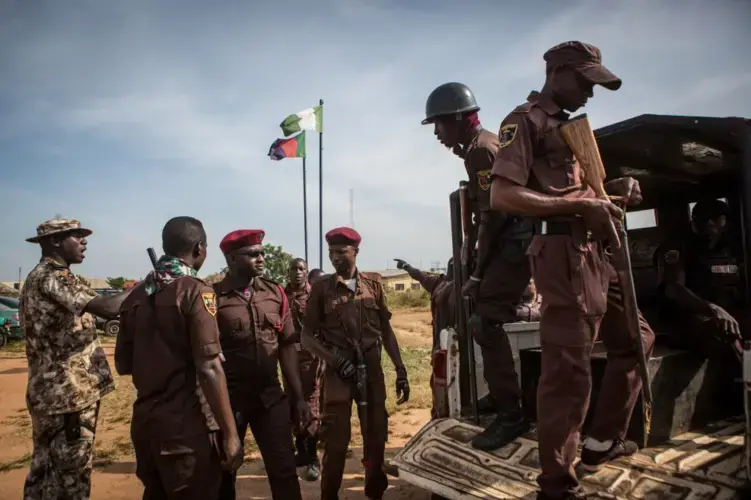 Vigilantes prepare for duty in Barkin Ladi in October. The volunteers provide their own weapons and are viewed as peacekeepers. Image by Jane Hahn. Nigeria, 2018.