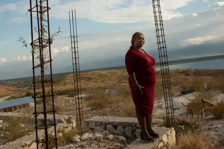 Carmen Cean, a.k.a. 'Madame Roy,' poses for a photo on a foundation near her home on a hilltop in the Village de Pecheur neighborhood of greater Canaan. Image by Allison Shelley. Haiti, 2019.