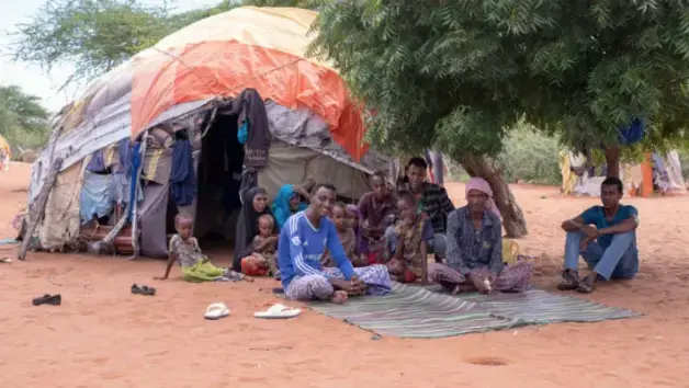 Ahmed Mohamed Saney, 56, (second from left), a father of 14, with his family in Wajir. He was registered to HSNP in 2013 but has received the cash transfers only three times. Image by Peter DiCampo. Kenya, 2019.