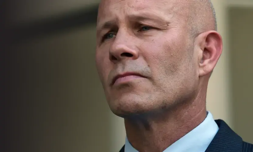 Retired Baltimore City Police Sgt. Keith Gladstone listens as his attorney David Irwin speaks with the media outside the federal courthouse after Gladstone pleaded guilty on May 31. He was accused in 2014 of planting a toy gun to justify Sgt. Wayne Jenkins running down a man with his vehicle. Baltimore, Maryland, 2019. Image by Kim Hairston.