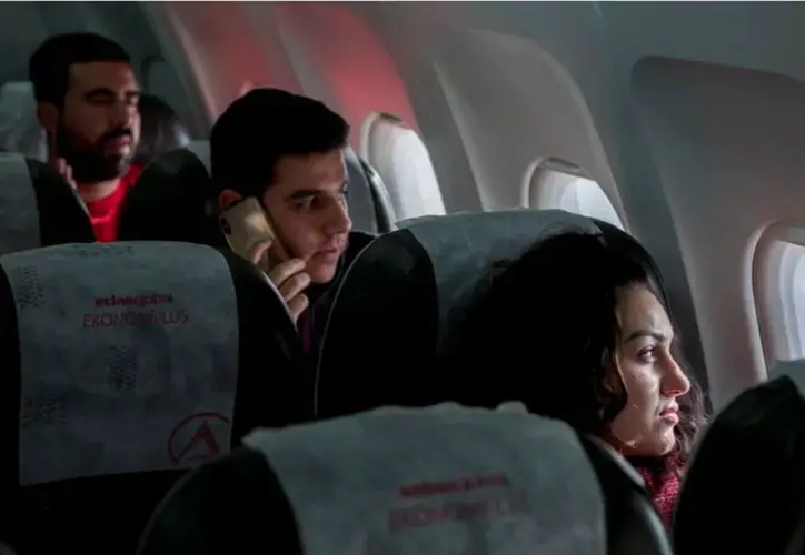 Zahra Ahmad looks out the window of an Atlas Global flight before departing to Erbil, Iraqi-Kurdistan, from Istanbul Atatrk Airport in Istanbul, Turkey on Monday, Feb. 4, 2019. Image by Brontë Wittpenn. Turkey, 2019.