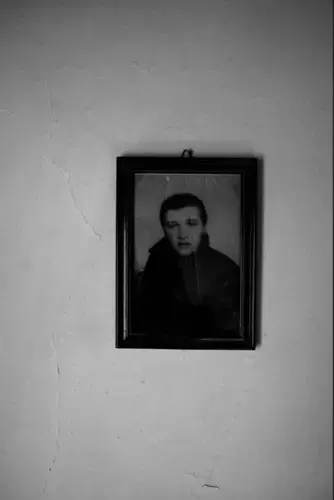 Sugra Mustafic's deceased husband on a wall of her barrack in Ježevac refugee camp, Banovići. Image by Jošt Franko. Bosnia and Herzegovina, 2017.