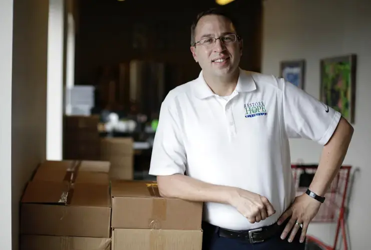 The Rev. Jeff Jaynes, executive director of Restore Hope Ministries, and his team facilitate the disbursement of funds from the Landlord Tenant Relief Program. The program aims to keep renters facing eviction in their homes during the pandemic. The Tulsa nonprofit has been providing rental assistance for over two decades. Image by Mike Simons. United States, 2020.<br />
