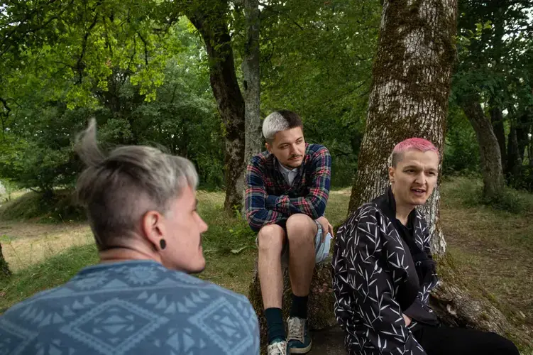 Sergi (facing camera) and Igor (left), chat with a friend visiting from Odessa. Image by Bradley Secker. France, 2020.