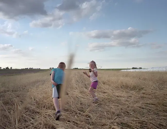 Children play in Tim Sieren’s cover crops while the Practical Farmers of Iowa group meet about conservation implementation. Image by Spike Johnson. United States, 2019.