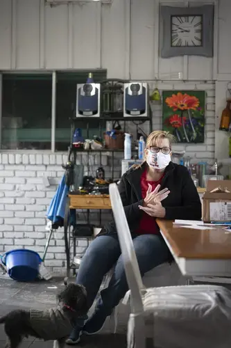 Teri Johnson, president of the Calcasieu Federation of Teachers and School Employees, sits in her temporary office in her home. The teachers’ union office was destroyed by Hurricane Laura. Image by Katie Sikora. United States, 2020.