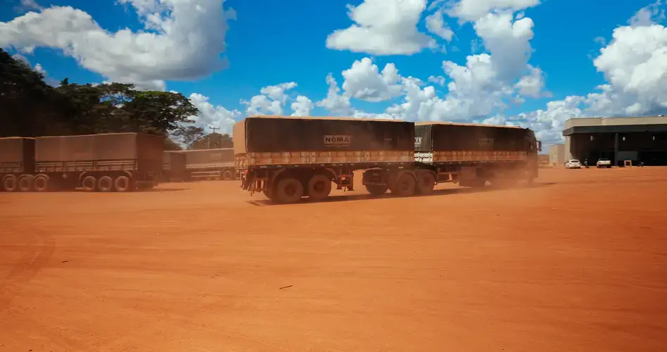Soy trucks kick up dust as they approach a warehouse in Mato Grosso. Image by Sam Eaton. Brazil, 2018.