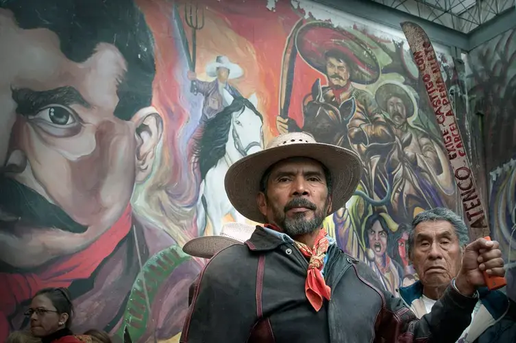 Shortly after the 2012 election, a man in San Salvador Atenco holds a machete inscribed with a demand that Peña Nieto be sent to jail. Image by Sari Dennise. Mexico, 2012.<br />
