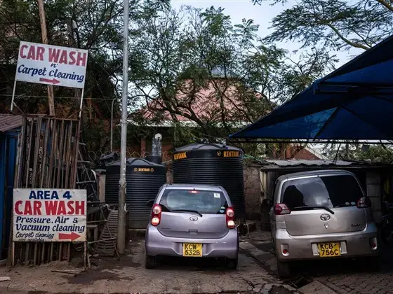 An Uber driver in Nairobi, Kenya, gets ready last month to pull out of the car wash where he parks his vehicle each night and begin his work day. Image by Nichole Sobecki/NBC News. Kenya, 2020.<br />
