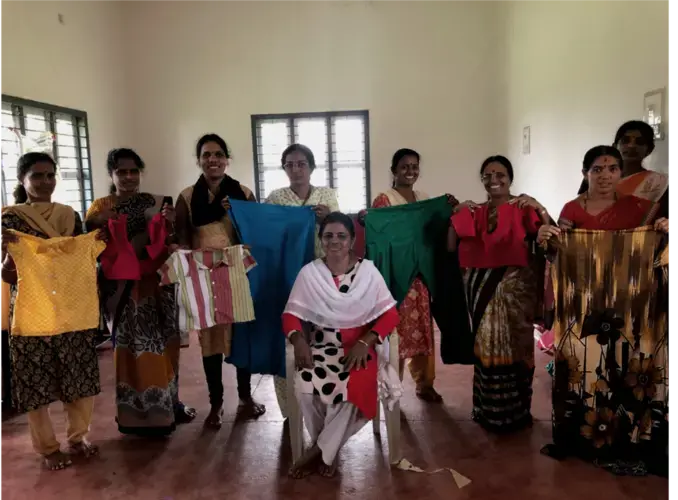 Beedi workers hold up blouses that they stitched during an exam at a tailoring centre in Mangalore, Karnataka. Image by Pallavi Puri. India, 2019.