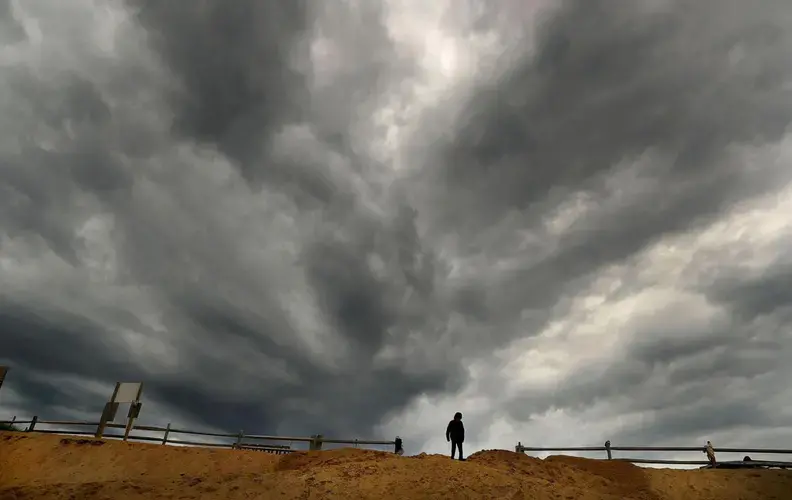 The leading edge of storm clouds from Hurricane Dorian looked ominous above the sand cliff leading to Newcomb Hollow Beach. Image by John Tlumacki. United States, 2019.