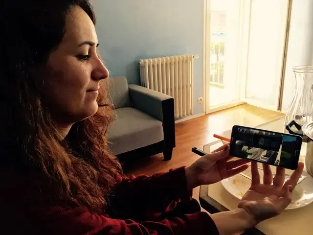 Inside the Nohs' apartment in Saint-Nazaire, Suham Noh shows a photo of the family home they had to flee in the Sinjar region of Iraq. Image by Jeanne Carstensen. France, 2017.