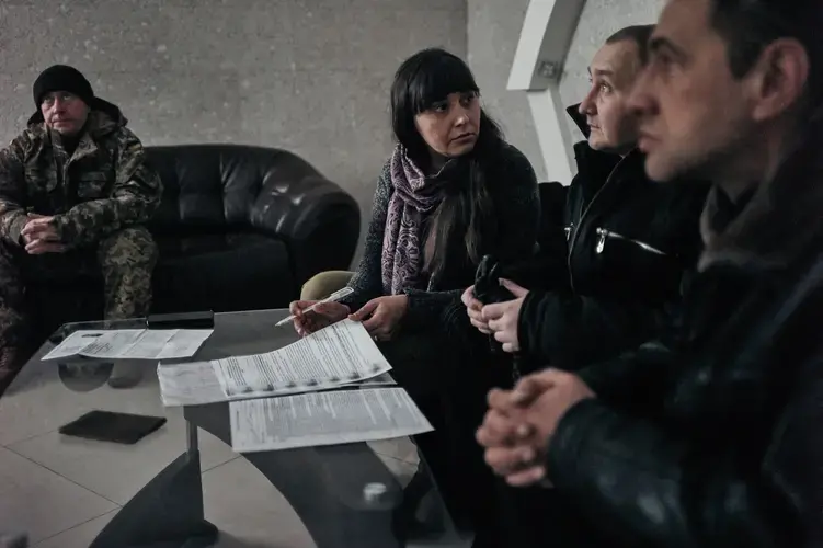 Olga, an outreach worker with Svitanok, works with people fleeing rebel-controlled areas. Here, she is seen helping someone rent an apartment in Krasnoarmeisk in 2016. Image by Misha Friedman. Ukraine, 2016.<br />
