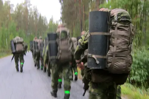 On a hike with the Sweden military, the column picks up the pace. Image by Teresa Fazio. Sweden, 2018.