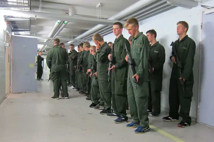 Recruits wait to turn in their weapons at the end of the night. Image by Teresa Fazio. Sweden, 2018.