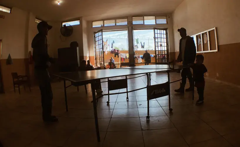 Migrants at a ping pong table before the Nazareth shelter closed to newcomers. Image by Daniel Mendez. Mexico, 2020.