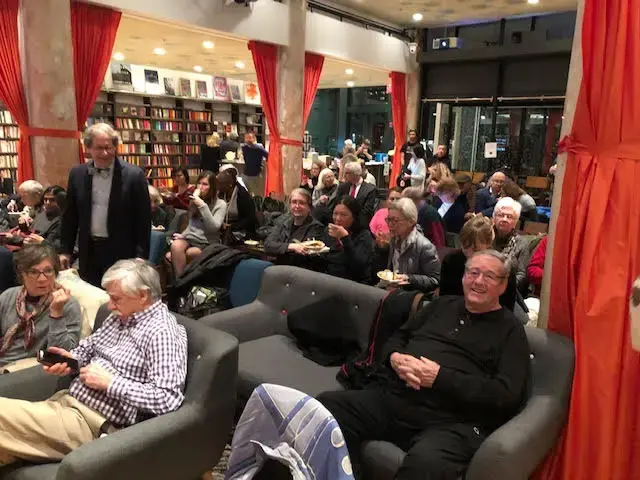 Audience members enjoy noodles from Everyday Noodles as Henry Reese, City of Asylum co-founder and President (left), takes his seat. Image by Kem Knapp Sawyer. United States, 2018.